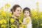 Portrait of a young happy mother embraced her little girl at canola field