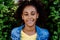 Portrait of young happy multiracial teenage girl with afro hairstyle, standing outdoor in park.