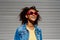 Portrait of young happy multiracial teenage girl with sunglasses and afro hairstyle, standing outdoor.