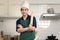 Portrait of young happy smiling Asian man with apron and chef hat holding wooden rolling kneading stick, standing with arms at