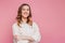 Portrait of a young happy smiling caucasian student girl with wavy hair in a beige corduroy jacket isolated on pink background,