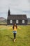 Portrait of young happy woman near Famous black church of Budir in Iceland.