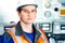 Portrait of young heavy industry engineer in protective vest and work clothes and helmet. Confident worker