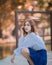 Portrait of young hipster Asian girl posing in the autume park forest background