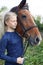 Portrait of young horsewoman and brown horse.