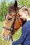 Portrait of young horsewoman and brown horse.