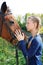 Portrait of young horsewoman and brown horse.