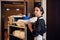 A portrait of a young hotel maid with a cleaning cart