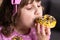 Portrait of young hungry girl eating donut. Female mouth bites a loaf. Close-up woman eating donut , delicious, sweet