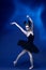 Portrait of young incredibly beautiful woman, ballerina in black ballet outfit, tutu dancing at blue studio full of