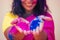 Portrait of young Indian face in paint Woman in traditional indian pink outfit with jeweler celebrating Holi color