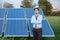 Portrait young indian technician or manager wearing formal cloths standing with solar panel. renewable energy,