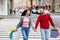 Portrait of young international couple with colorful gift bags crossing street, holding hands outdoors