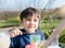 Portrait Young kid drinking fresh juice for breakfast in cafe, Happy child boy drinking glass of soda or soft cold drink while