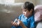 Portrait of young Kid holding money coins in clear jar,  Child counting his saved coins, Happy Childhood siting on sofa hand