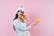 Portrait of young latin woman holding maracas rattle with copy space in a christmas concept on pink background