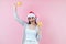 Portrait of young latin woman holding maracas rattle with copy space in a christmas concept on pink background