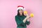 Portrait of young latin woman holding maracas rattle with copy space in a christmas concept on pink background