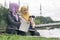 Portrait of young lovely pleasant mix ethnic woman sitting on grass at summer green park and having a discussion