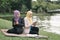 Portrait of young lovely pleasant mix ethnic woman sitting on grass at summer green park and having a discussion