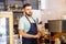 Portrait of a young male baristas at a bar counter near a coffee machine