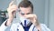 Portrait of young male caucasian doctor pouring a liquid from a syringe to a tube