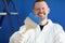 Portrait of young male construction worker in protective suit with paintbrush and paint