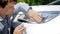 Portrait of young male driver cleaning car headlamps