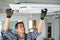 Portrait of young male indian technician repairing air conditioner. Air conditioner repairs.