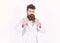 Portrait of a young man in bathrobe isolated on white background. Macho adjusting collar of his robe. Bearded guy in