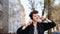 Portrait of young man commuter with headphones walking outdoors in city, listening to music.