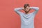 Portrait of young man covering both ears with hands on red background. Suffering from loud sound