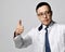 Portrait of young man doctor urologist or proctologist in white medical gown gesturing thumb up sign