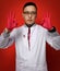 Portrait of young man doctor urologist or proctologist in white medical gown and red latex gloves gesturing OK sign