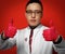 Portrait of young man doctor urologist or proctologist in white medical gown and red latex gloves gesturing thumbs up
