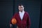 Portrait of young man with down syndrom holding basketball ball.