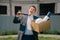 Portrait of a young man, a European, holding a box of office supplies, leaves the office building