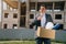 Portrait of a young man, European holding a box with things in his hands, leaving the office