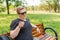 Portrait of a young man on nature background. Emotion facial expression. The guy is sitting on the bench and pointing