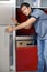 Portrait of young man opening door of refrigerator