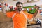 portrait of young man in orange fan t-shirt holding striped scarf and celebrating victory in soccer match