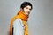 Portrait of young man with orange scarf and grey bomber.