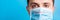 Portrait of young man in protective mask with pandemic text at blue background. and health care concept