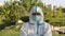 A portrait of a young man in a protective suit, glasses and a mask looks at the camera and waves his head no, yes, makes