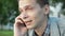 Portrait of young man talking on phone. Outdoor. Summer day. Communication