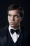 Portrait of young man in tuxedo isolated on dark