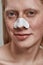 Portrait of young man using nose pore cleansing strips