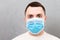 Portrait of young man wearing medical mask Stay home at gray cement background. Coronavirus self isolation concept. Respiratory