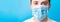 Portrait of young man wearing medical mask with Stay home word at blue background. Coronavirus self isolation concept. Respiratory