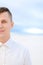 Portrait of young man in white steppe background, wearing shirt.